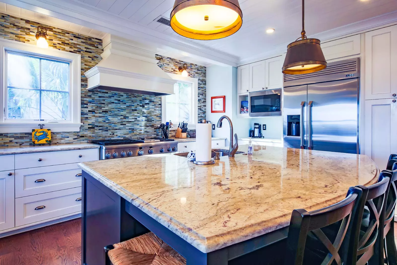 The kitchen features stainless steel appliances, including a range, built-in refrigerator and two dishwashers.