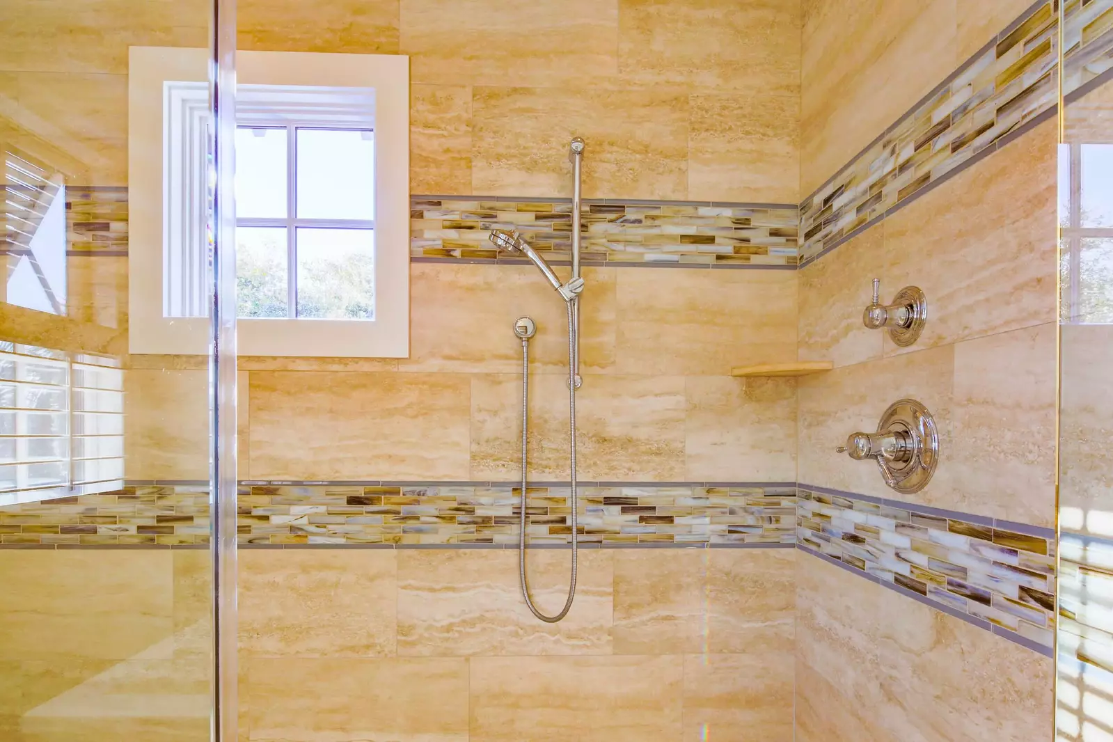The walk-in shower in the master bathroom has multiple shower heads.