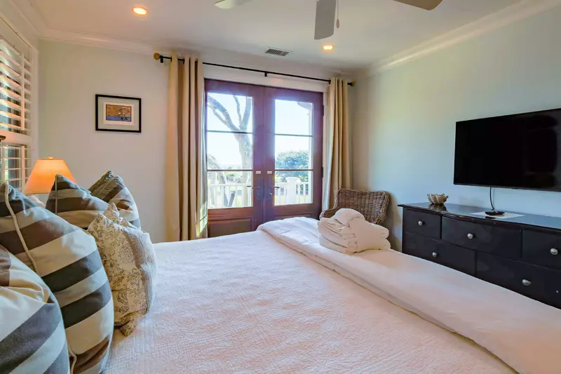 This master suite on the home's lower level also has a king bed, dresser and mounted TV.