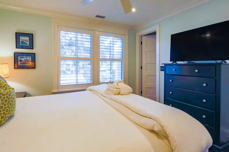 This guest suite features a king bed, night stands with reading lamps and dresser with TV.