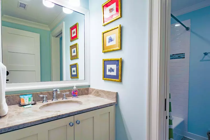 The en suite bathroom for this lower level guest suite features a shower/tub combo.