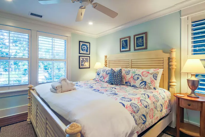 This guest suite on the home's lower level features a king bed and night stands with reading lamps.