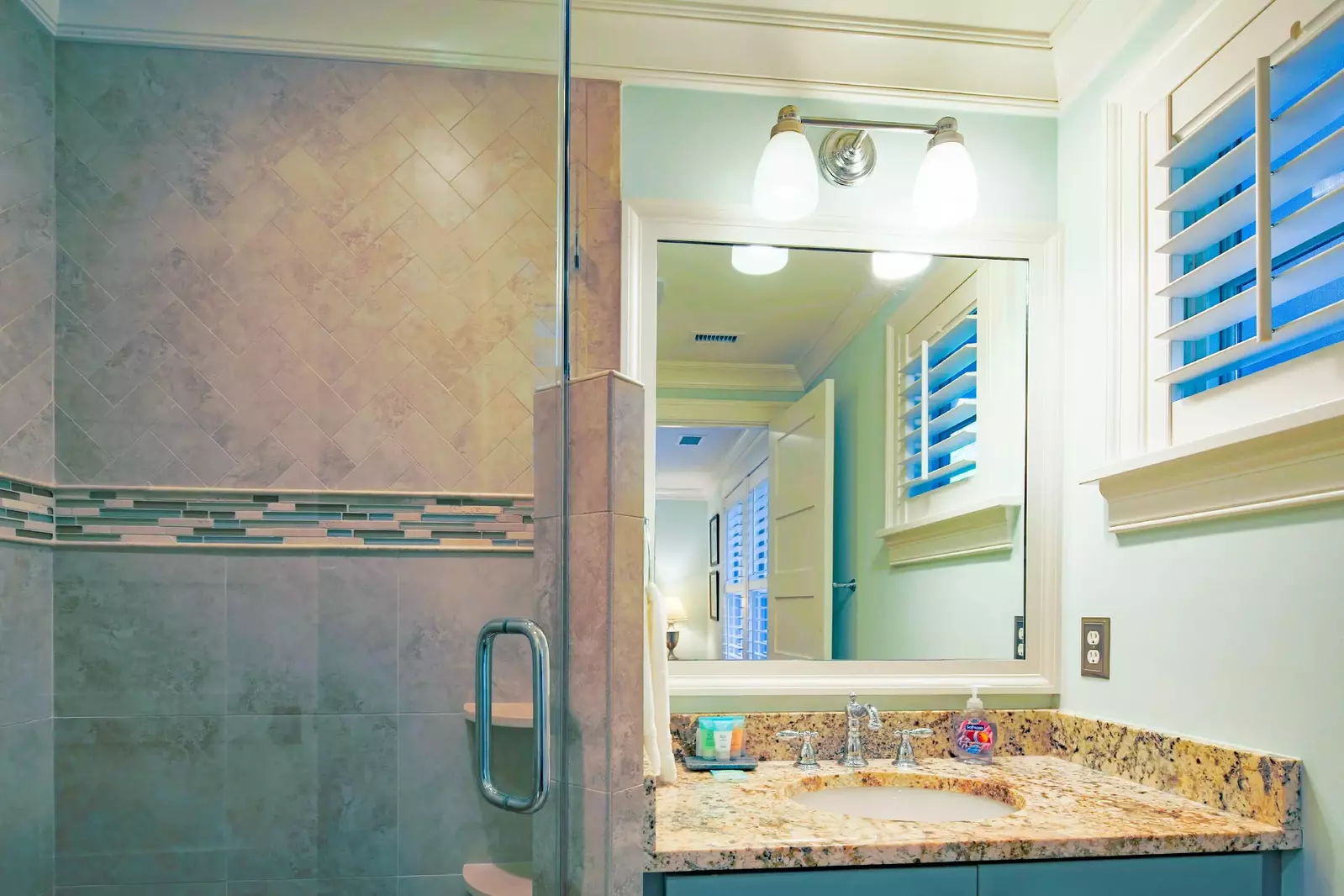 The en suite bathroom features a vanity and tiled, walk-in shower.