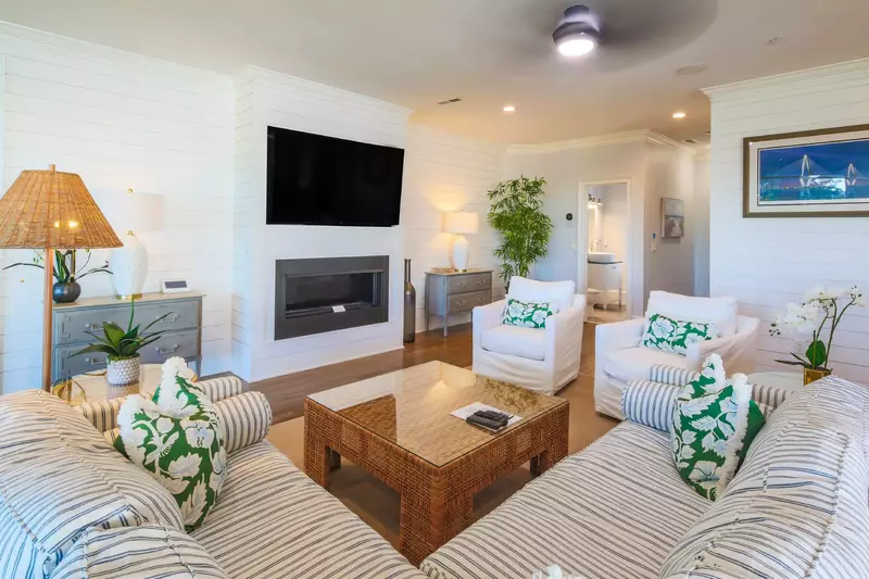 You'll find the living room with shiplap walls and mounted large screen TV on the second level of the home.