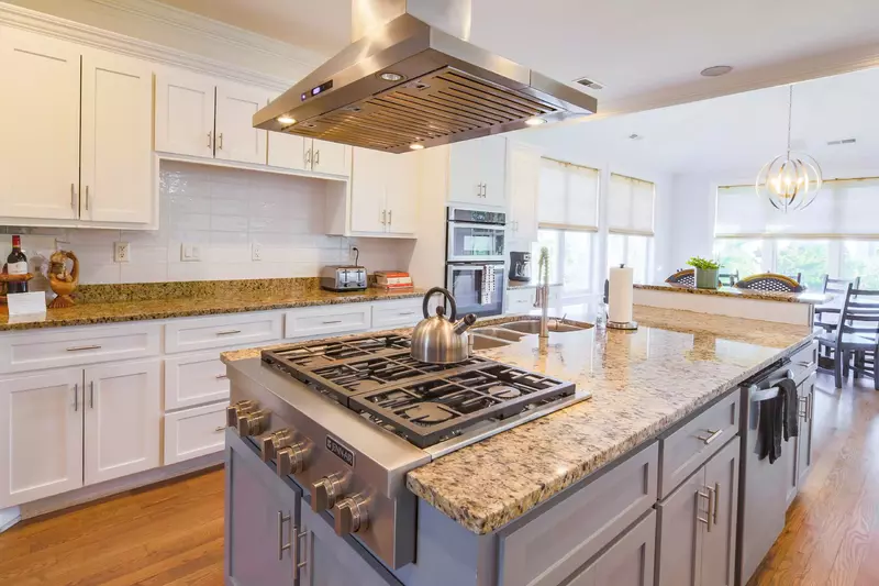 The kitchen features stainless steel appliances, granite countertops and a large island.