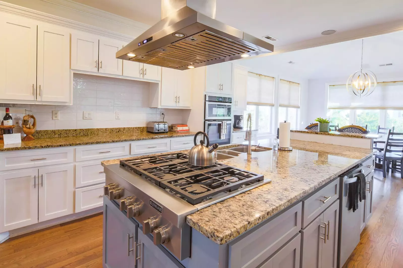 The kitchen features stainless steel appliances, granite countertops and a large island.