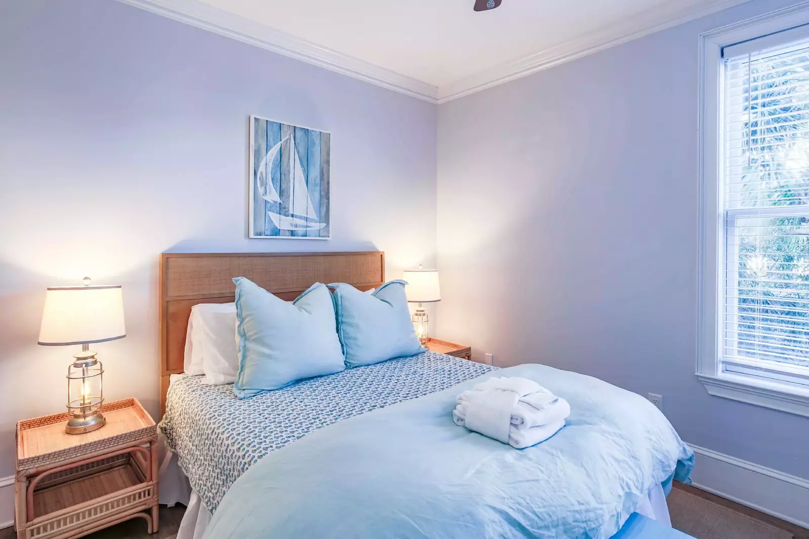 This bedroom on the first floor features a queen bed and night stands with reading lamps.