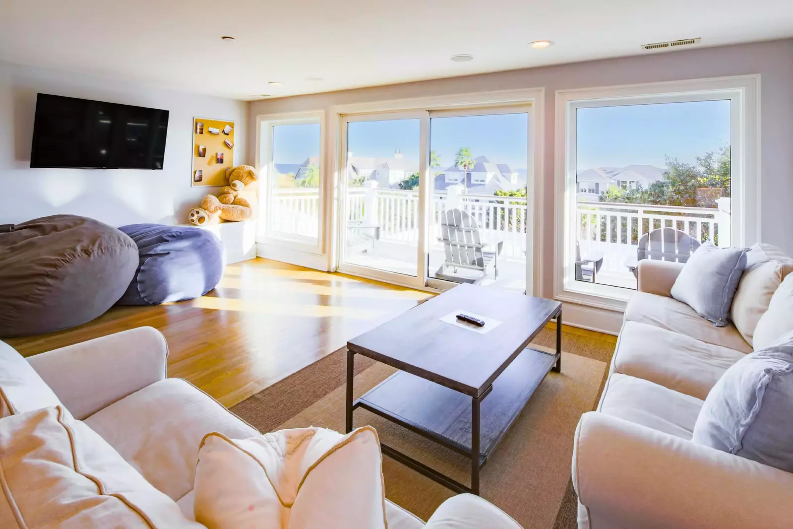 This third floor game room features ocean views, a wall mounted TV and sliding door access to the balcony.