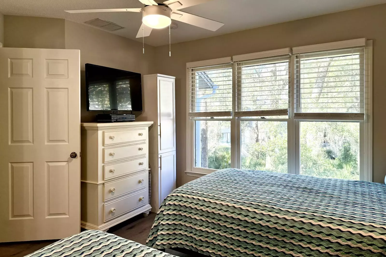 Guest Bedroom on the Second Level with TV and Ceiling Fan