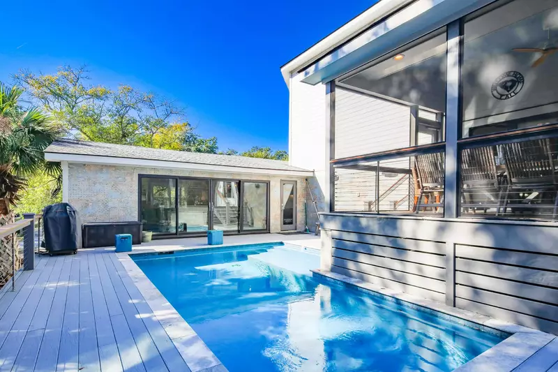 The screened porch overlooks the private pool and pool deck.
