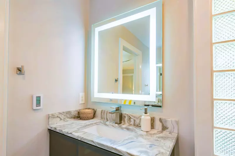 The en suite bathroom features two vanities -- each with a lighted mirror.
