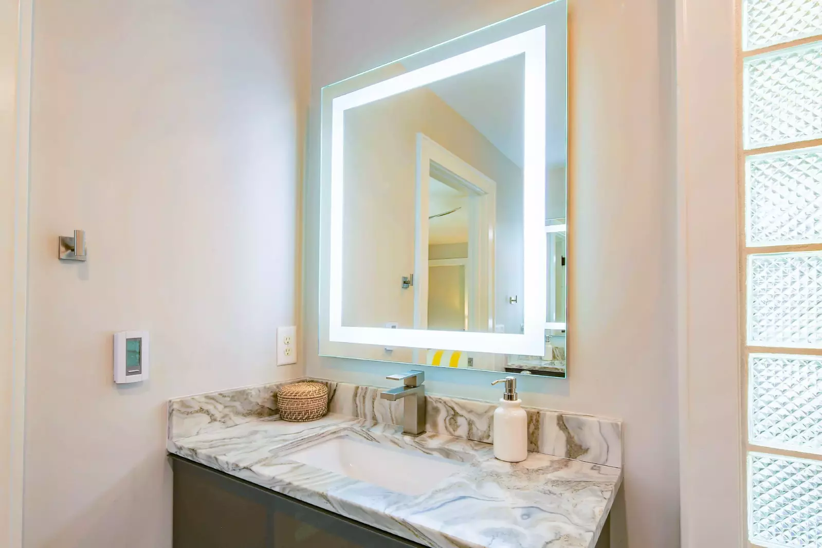 The en suite bathroom features two vanities -- each with a lighted mirror.