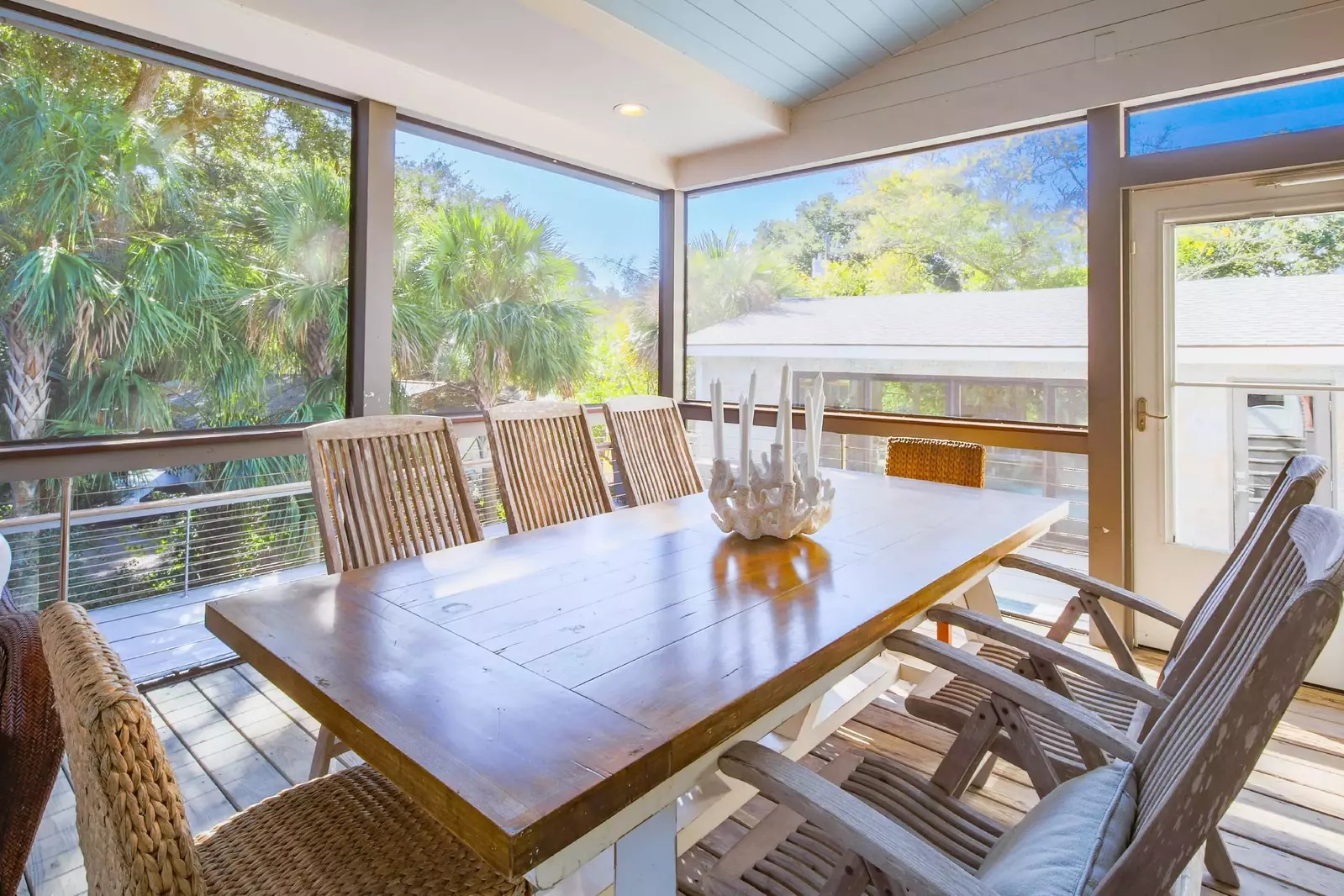 The screened porch features a large dining table that seats seven.