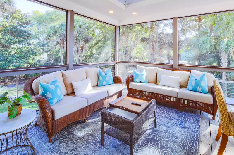 The screened porch also features this comfortable seating area with two sofas, a coffee table and end table.
