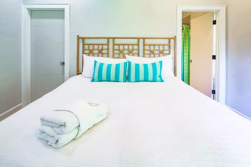 There is a closet to the left of the bed and an en suite bathroom to the right of the bed.