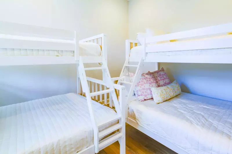 The bunk bedroom, which is located on the upper level, features two bunk beds with full beds on the bottom and twin beds on the top.