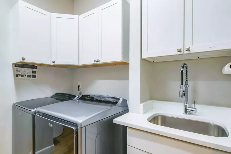 The home also has a spacious laundry room with full-sized washing machine, dryer and a utility sink.