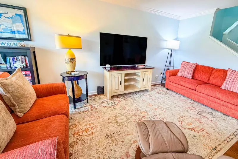 The living room features a sofa, love seat and smart TV.