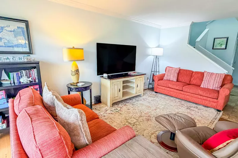 The stairwell adjacent to the living room leads to the bedrooms on the second floor.