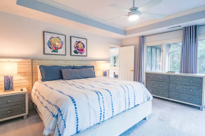 The primary suite features a king bed, night stands with reading lamps and a dresser.