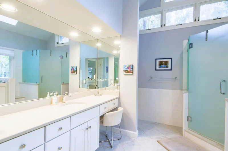 The primary en suite bathroom features a spacious vanity, vaulted ceilings and walk-in shower.
