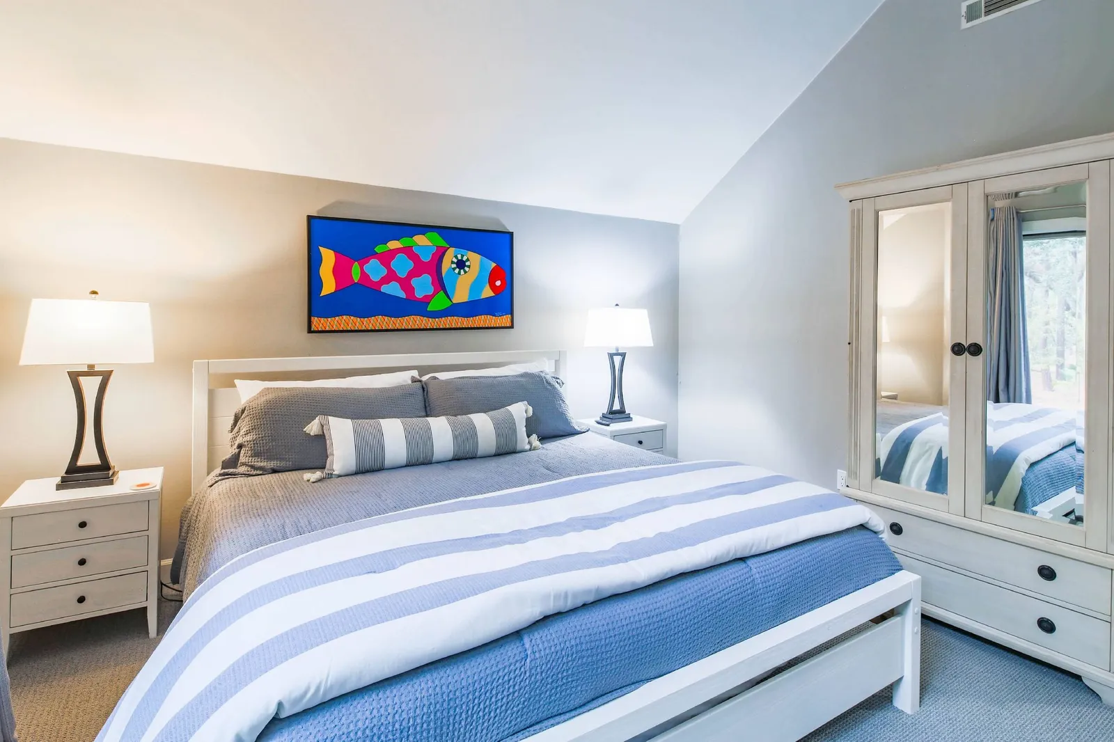 This suite features a king bed, armoire and night stands with lamps.