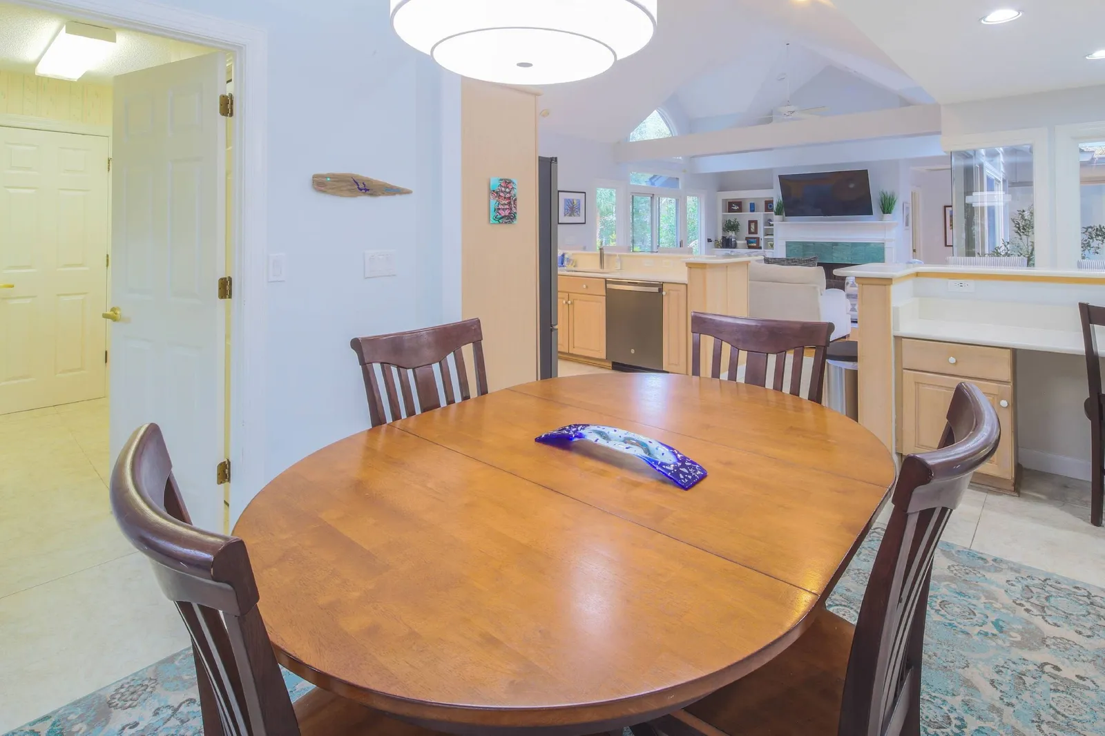 The laundry room is located near the dining table in the kitchen.