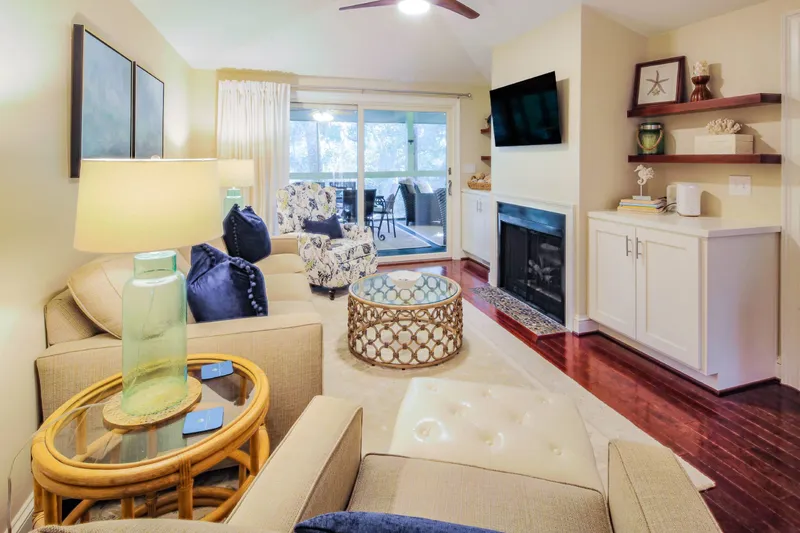 The living room also has a mounted smart TV and sliding door access to the screened porch.