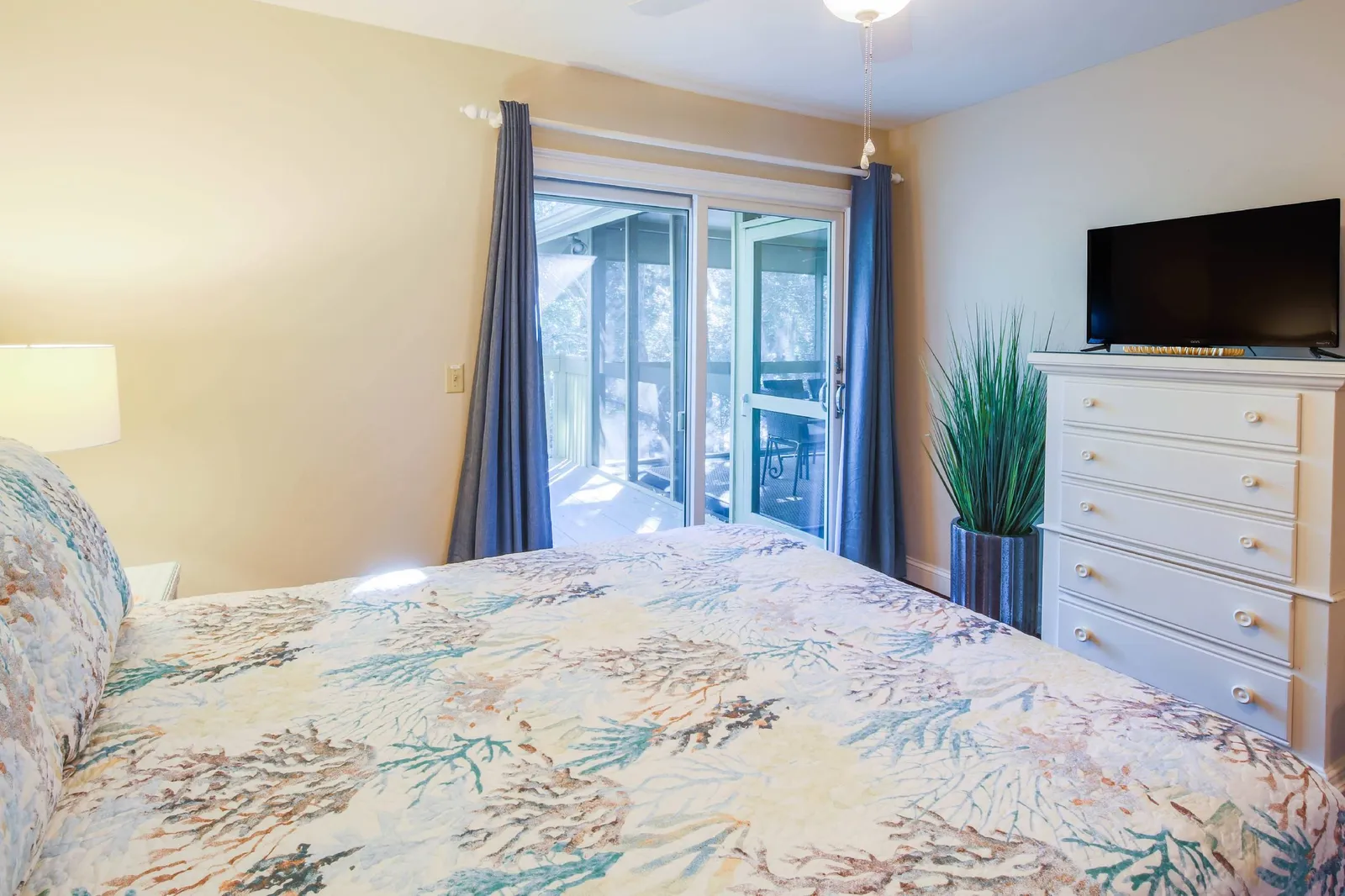 The queen bedroom also features a dresser, smart TV and sliding door access to the back deck.