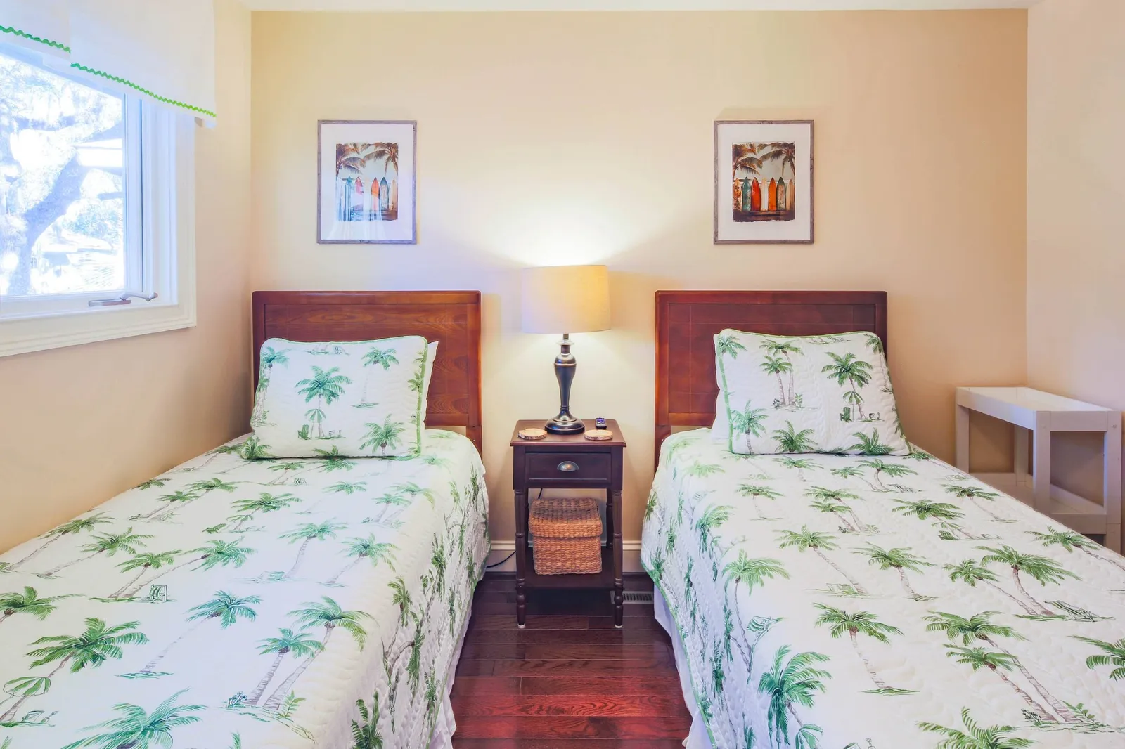 There are two night stands and a reading lamp in the twin bedroom.