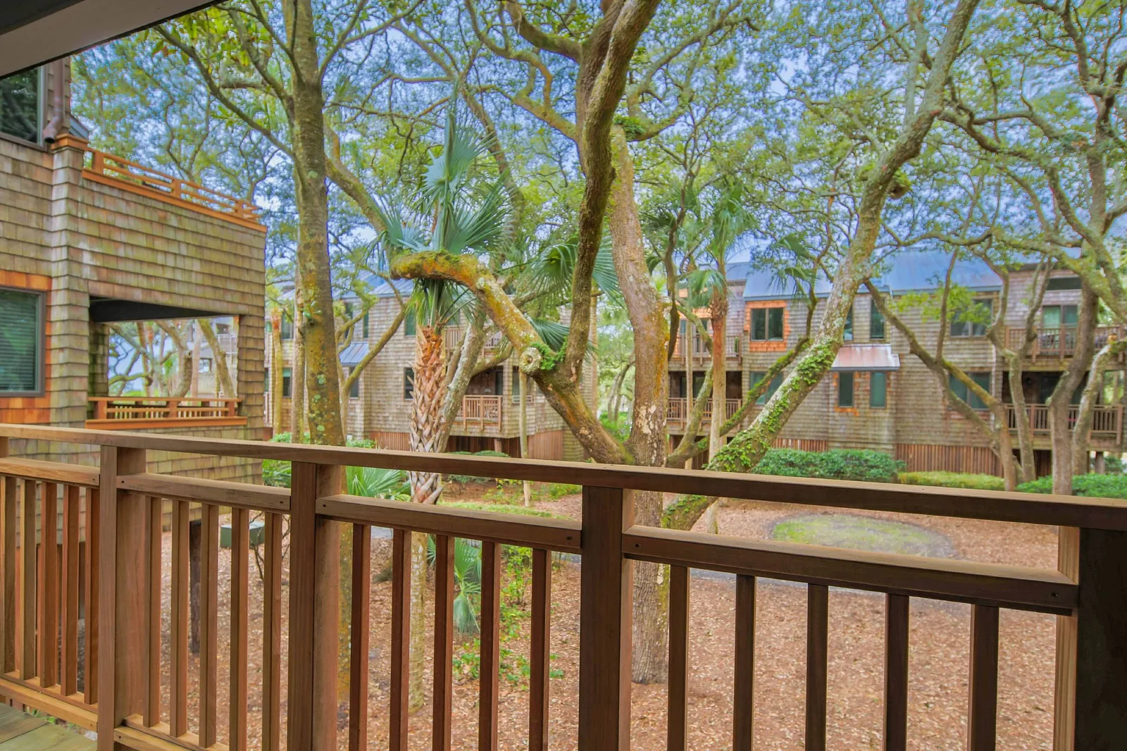 The living room and bedroom have shared access to this covered balcony with woodland views.