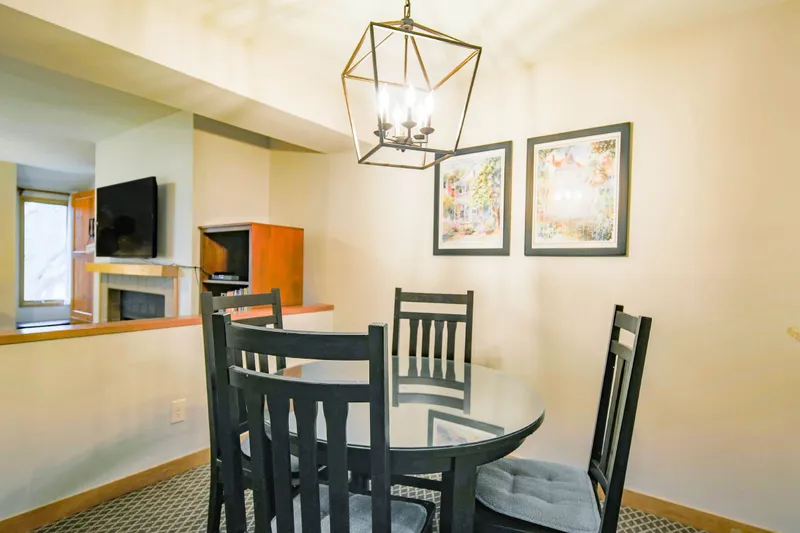 The dining area looks into the living room -- including the wall-mounted TV in the living room.