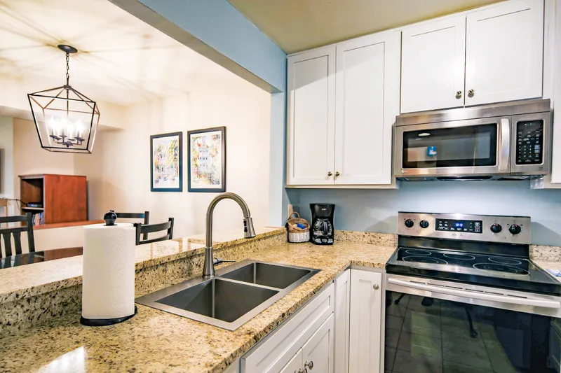 The kitchen features white cabinets, stainless steel appliances and granite countertops.
