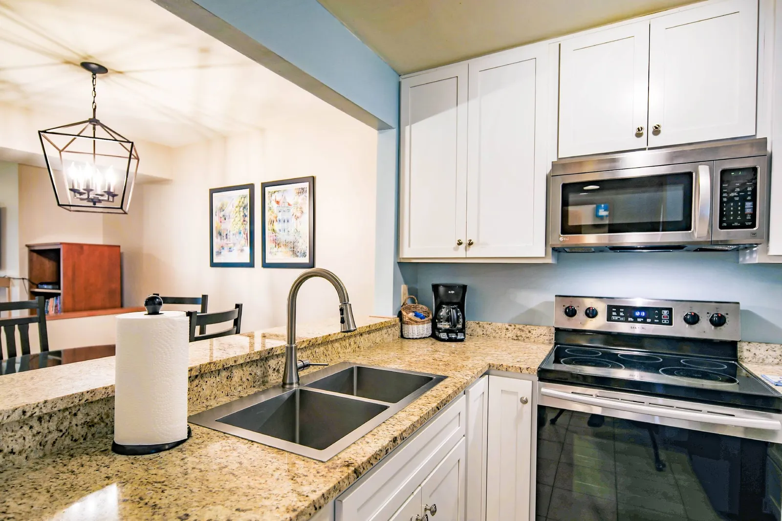 The kitchen features white cabinets, stainless steel appliances and granite countertops.