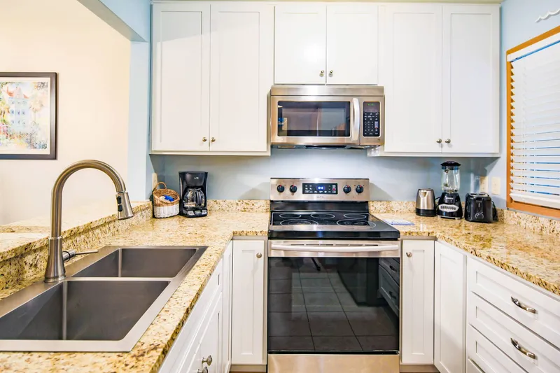 There is an electric range, microwave, drip coffee maker, blender, toaster and electric kettle.