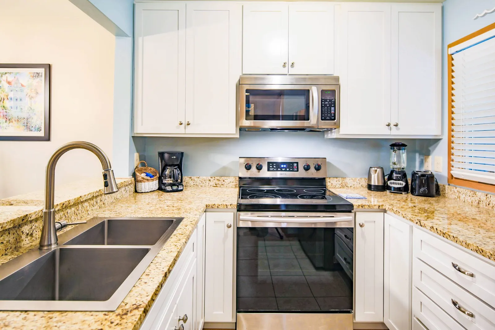 There is an electric range, microwave, drip coffee maker, blender, toaster and electric kettle.