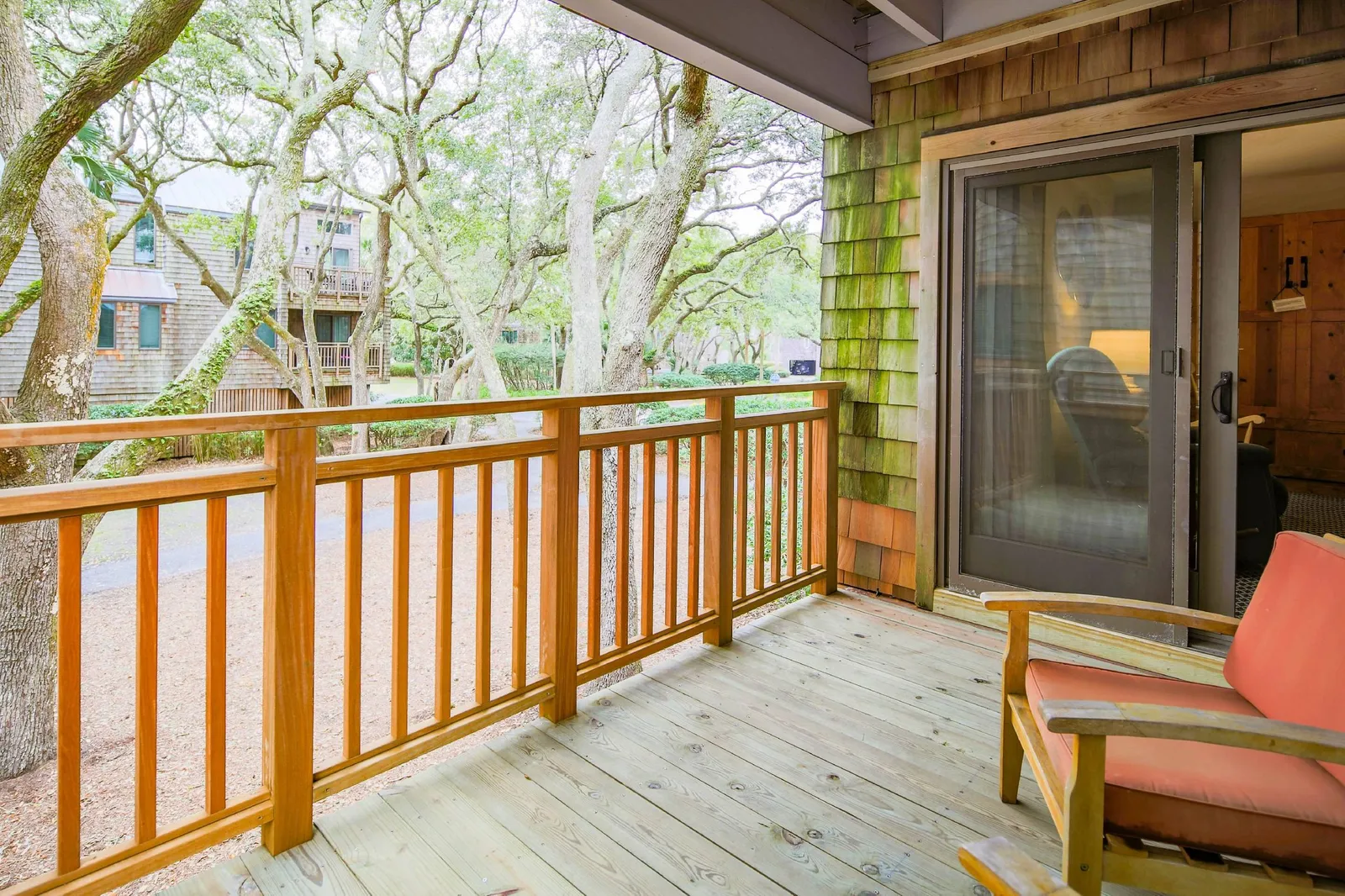 The covered balcony features two cushioned arm chairs.