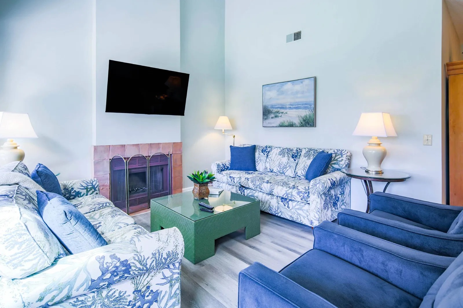 The home features a spacious living room with vaulted ceilings, TV, two sofas and two armchairs.