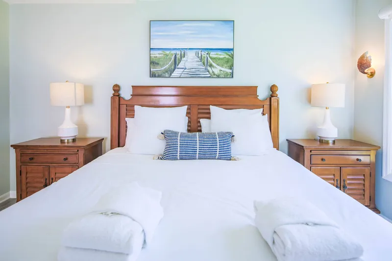 The primary suite features a king bed and night stands with reading lamps.