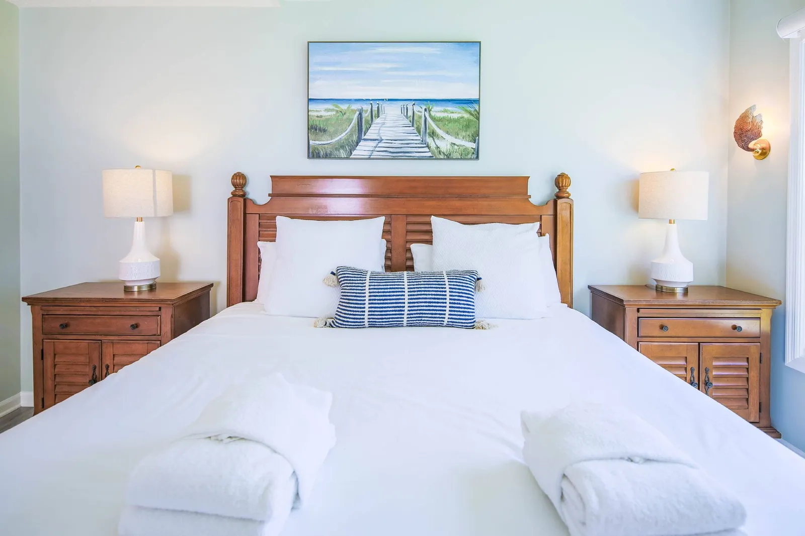 The primary suite features a king bed and night stands with reading lamps.