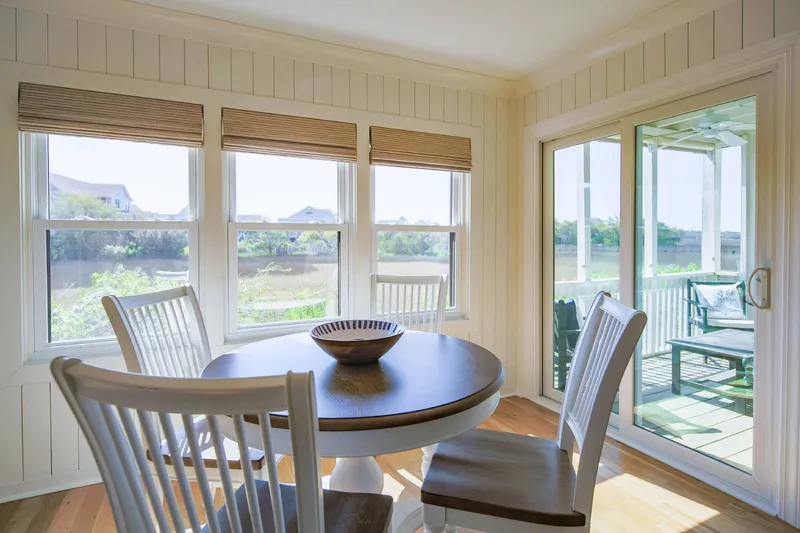 The dining table comfortably seats 4, and there is sliding door access to the screened porch.