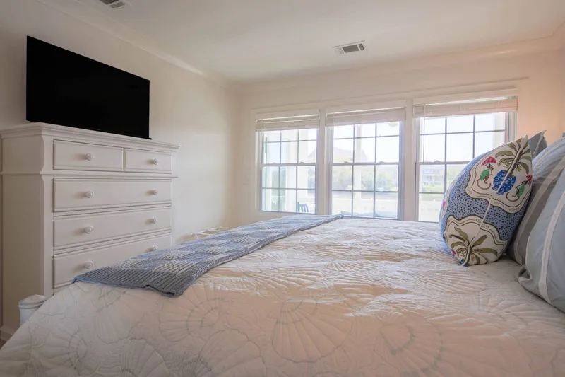 The bedroom looks out onto the screened porch and marsh.