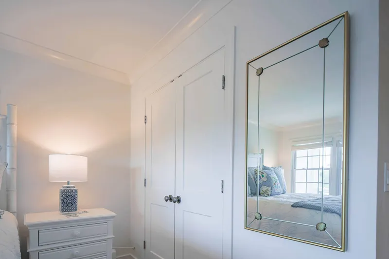 There is a wall mirror and closet in the bedroom.