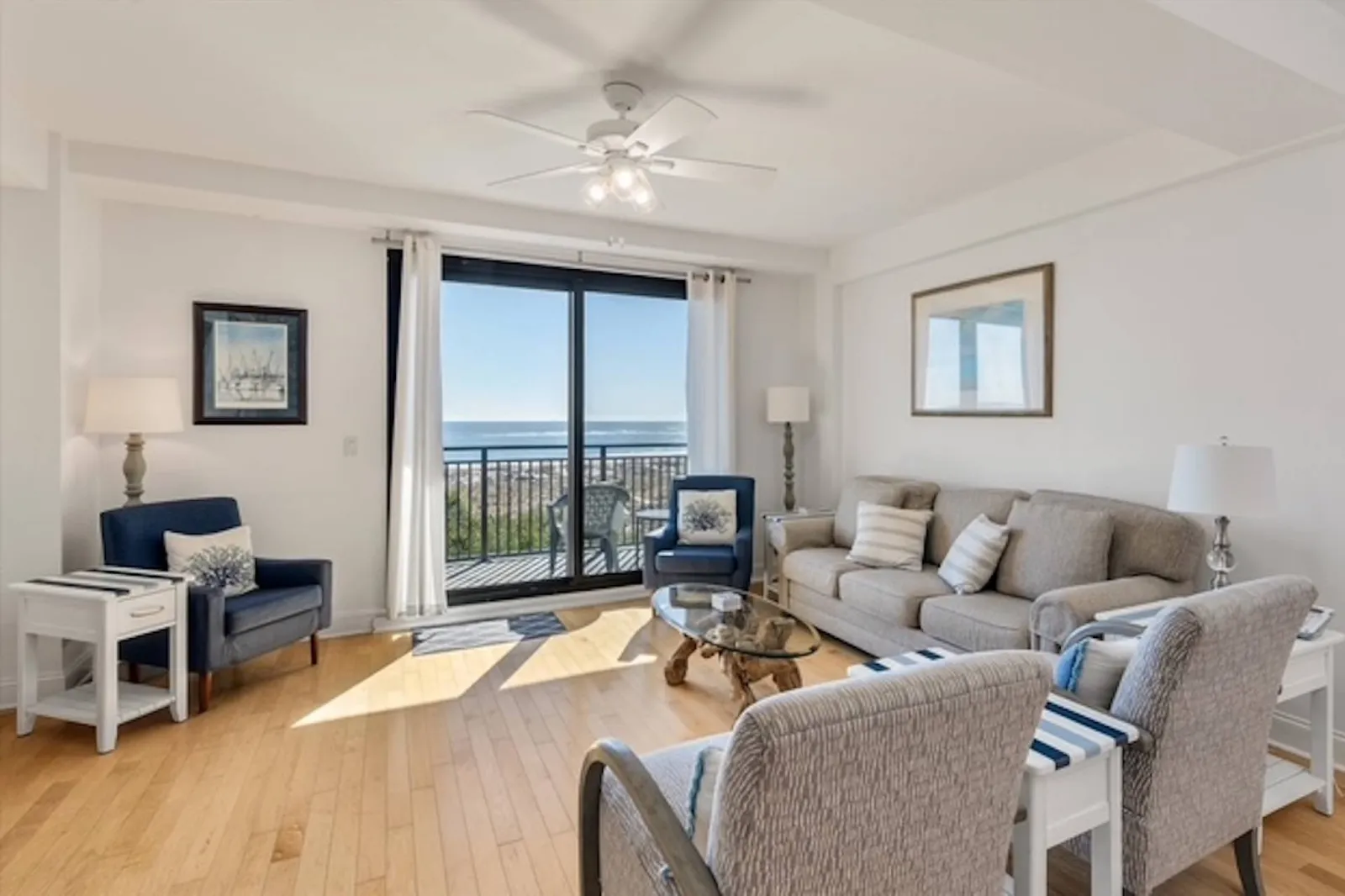 The living room features a spacious seating area, access to a balcony and stunning ocean views.