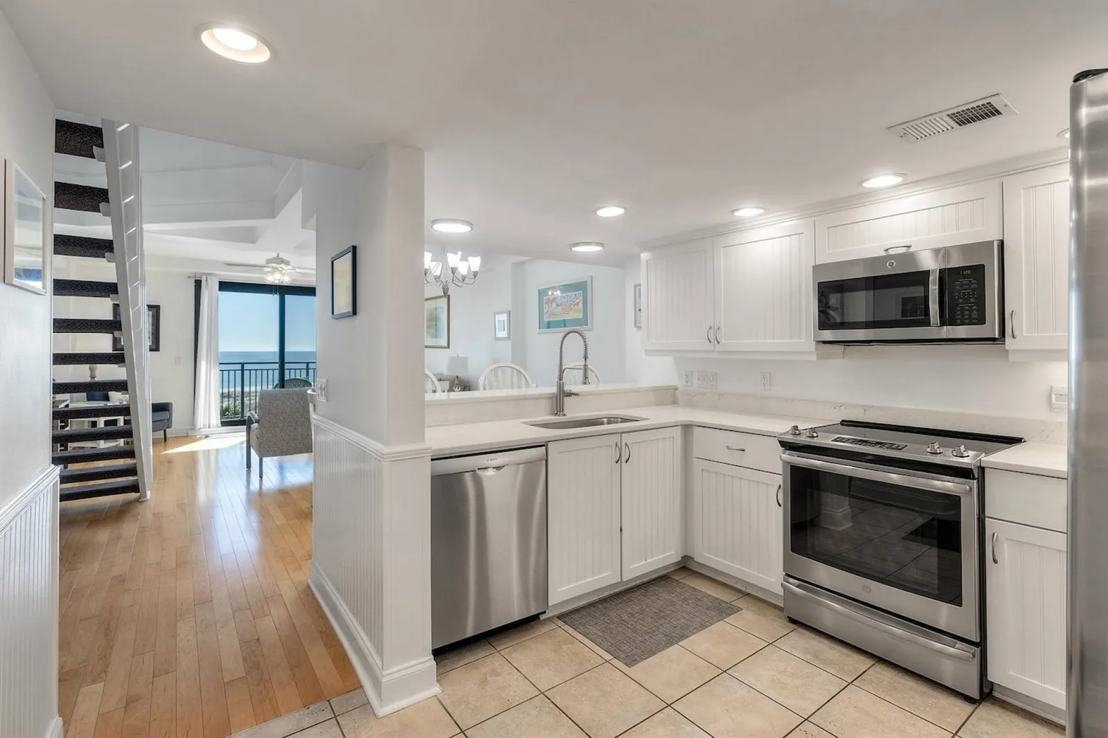 The kitchen features white cabinets and stainless steel appliances.