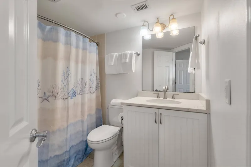 The en suite bathroom features a white vanity and a shower/tub combo.