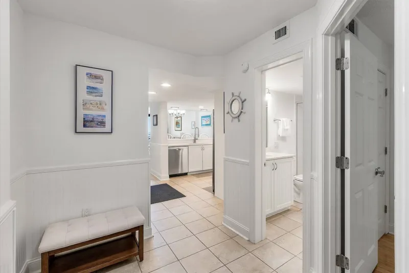 You can access the hallway bathroom and the guest bedroom from the entryway area near the kitchen.