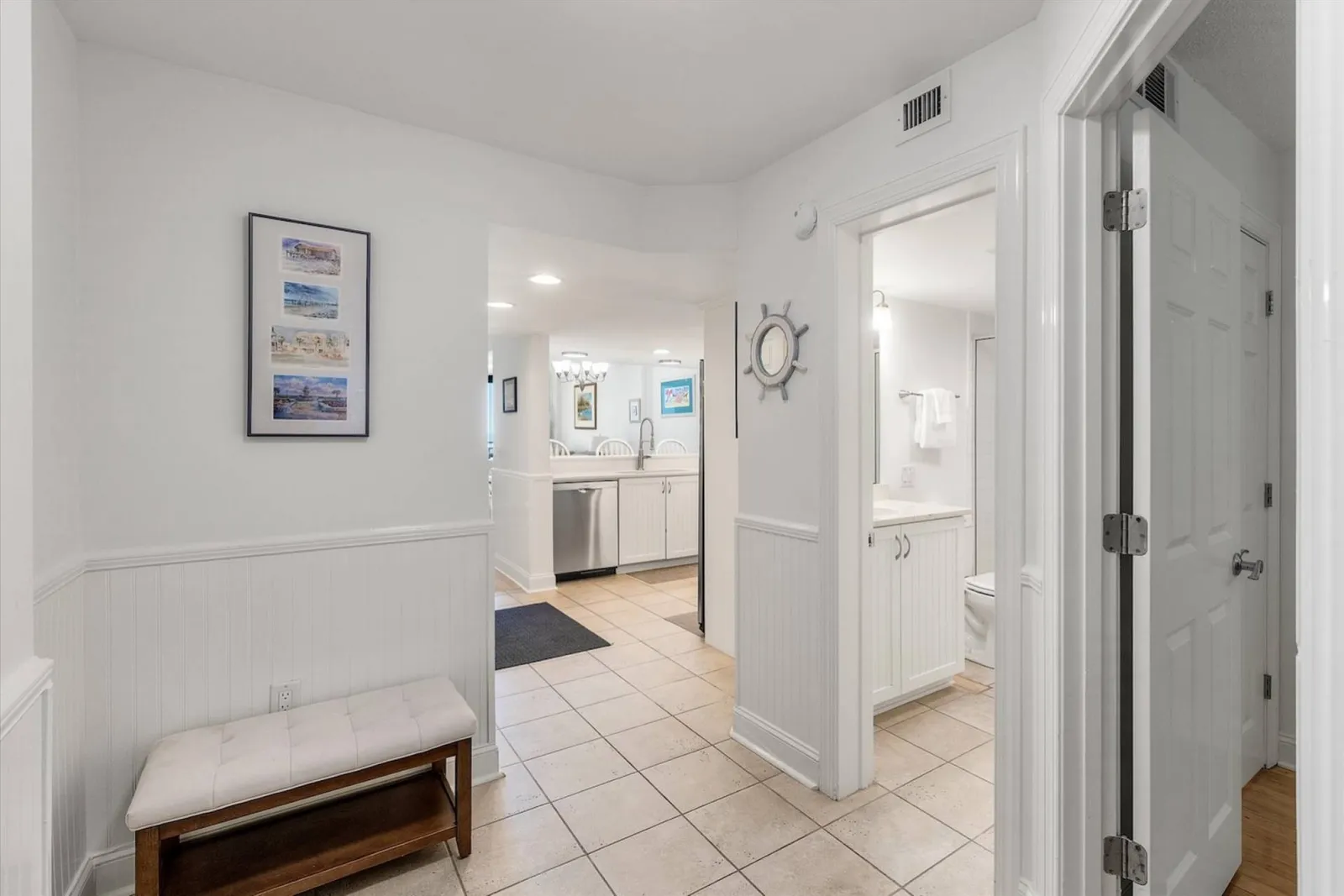 You can access the hallway bathroom and the guest bedroom from the entryway area near the kitchen.