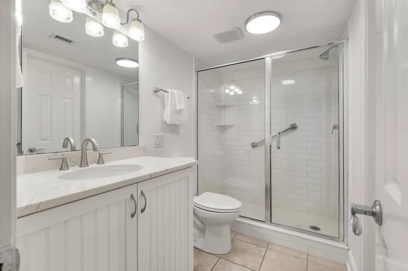 The hallway bathroom (which is also accessible via the guest bedroom) features a tiled, walk-in shower and vanity.
