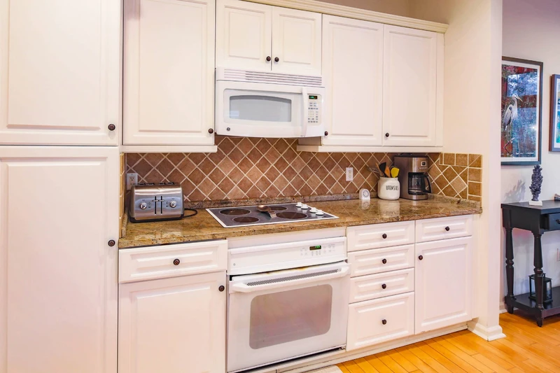 The kitchen features an electric range, microwave, toaster and drip coffee maker.